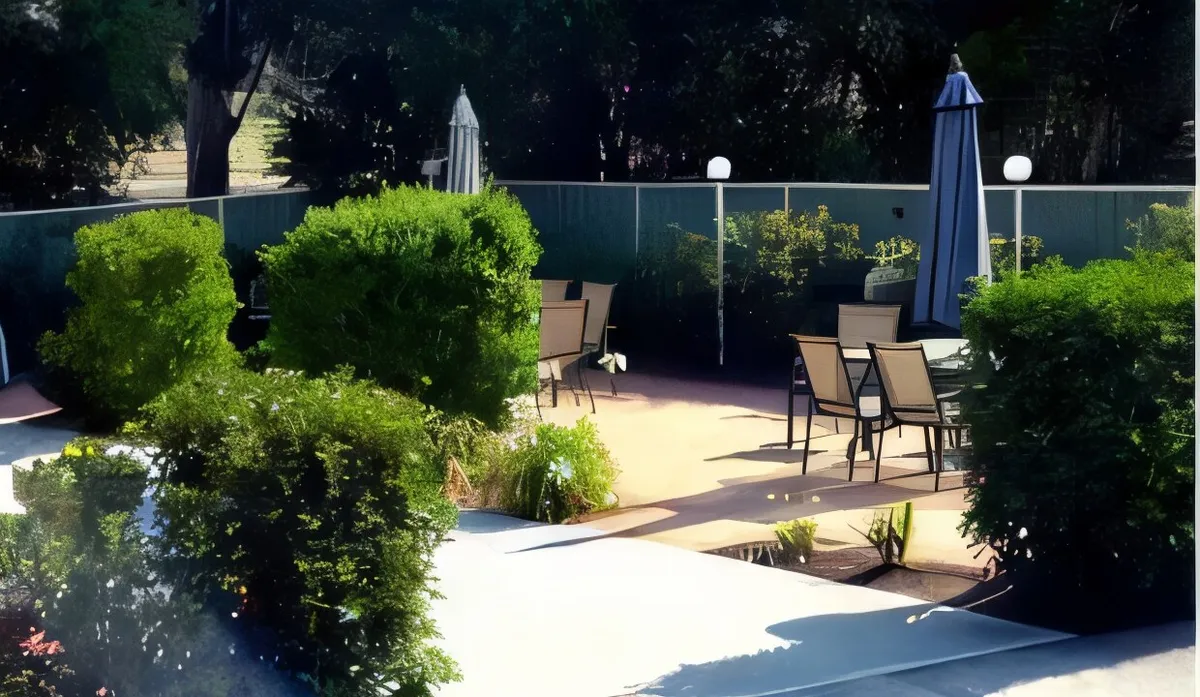 The landscaped courtyard garden with clipped hedges and shade umbrellas