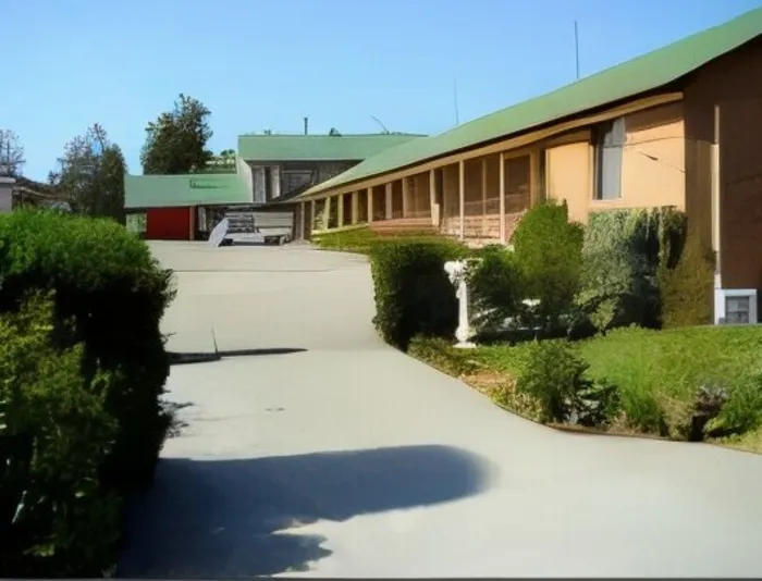 The driveway through the motel grounds with units under green roofs either side